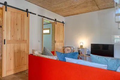a living room with a red couch and a tv at O Lagar do Avô, a Home in Madeira in São Jorge