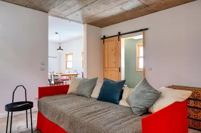 a bedroom with a red couch with blue pillows at O Lagar do Avô, a Home in Madeira in São Jorge