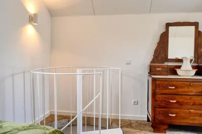 a room with a bed and a dresser and a mirror at O Lagar do Avô, a Home in Madeira in São Jorge