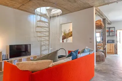 a living room with a red couch and a television at O Lagar do Avô, a Home in Madeira in São Jorge