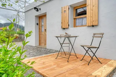 a table and two chairs sitting on a wooden deck at O Lagar do Avô, a Home in Madeira in São Jorge