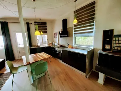 a kitchen with a wooden table and a counter top at Villa Sophia by ALMA Holiday Rentals in Caniço