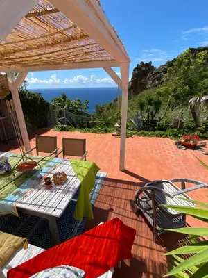 a patio with a table and chairs and the ocean at Villa Sophia by ALMA Holiday Rentals in Caniço