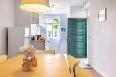 a dining room with a wooden table and a green door at CASA DA ROCHINHA in Funchal