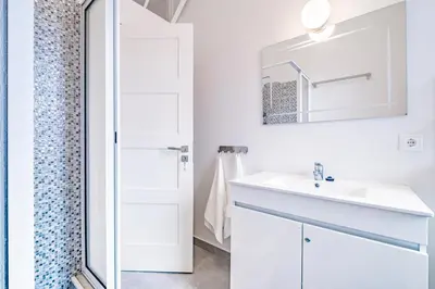 a white bathroom with a sink and a shower at CASA DA ROCHINHA in Funchal