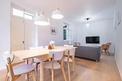 a dining room and living room with a table and chairs at CASA DA ROCHINHA in Funchal