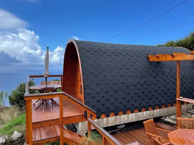 a house with a black roof and a deck at The tiny black bird in Fajã da Ovelha