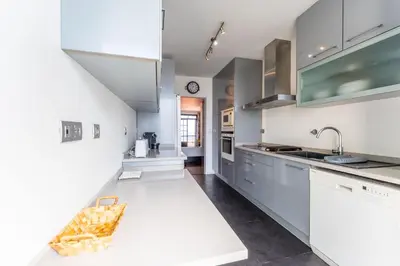a kitchen with white cabinets and a sink at FLH Funchal Artistic Apartment with Balcony in Funchal
