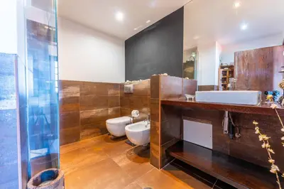 a bathroom with a toilet and a sink and a mirror at FLH Funchal Artistic Apartment with Balcony in Funchal