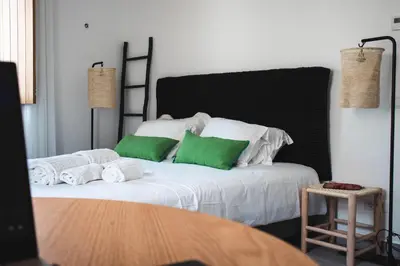 a bed with green and white pillows on it at Laurus - Charming House in Raposeira