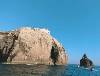 a building on top of a rock in the water at Laurus - Charming House in Raposeira