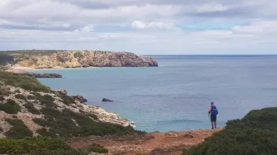 a woman standing on a cliff looking at the ocean at Laurus - Charming House in Raposeira