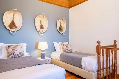 a room with wicker chairs and a table with a pillow at Rainbow Cottage by Homie in Ponta do Pargo
