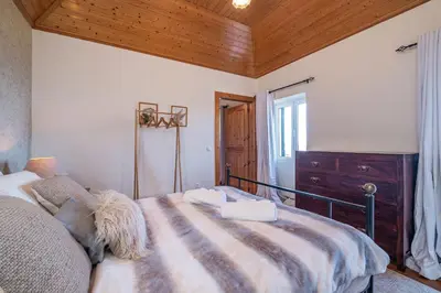 a bedroom with a bed and two night stands and two lamps at Rainbow Cottage by Homie in Ponta do Pargo