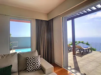 a living room with a couch and a sliding glass door at Villa Miradoura by LovelyStay in Arco da Calheta