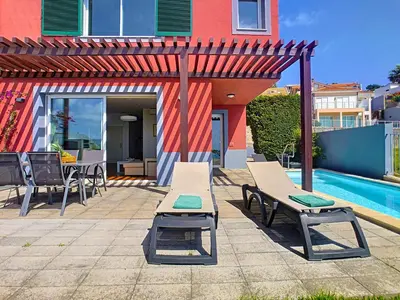 a patio with a table and chairs and a pool at Villa Miradoura by LovelyStay in Arco da Calheta