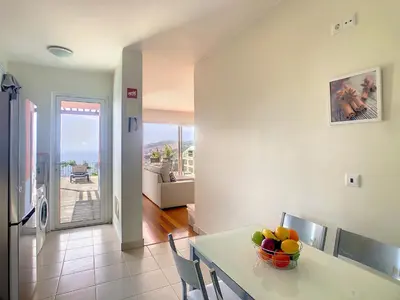 a kitchen with a table with a bowl of fruit on it at Villa Miradoura by LovelyStay in Arco da Calheta