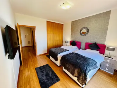 a bedroom with two beds and a flat screen tv at Villa Carpe Diem by Your Madeira Rentals in Estreito da Calheta