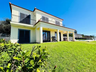 a house with a green lawn in front of it at Villa Carpe Diem by Your Madeira Rentals in Estreito da Calheta