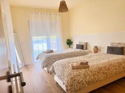two beds in a room with a window at Casa Kiko in Burgau