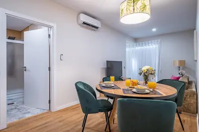 a dining room with a table and green chairs at Urban Paradise by Homie in Funchal