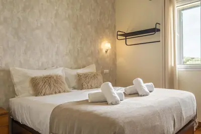 a bedroom with a bed with white sheets and pillows at Casas do Salao by Homie in Porto Moniz