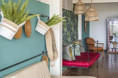 a living room with a red chair and potted plants at Casas do Salao by Homie in Porto Moniz