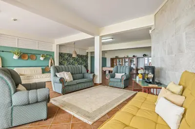 a living room with blue chairs and a couch at Casas do Salao by Homie in Porto Moniz