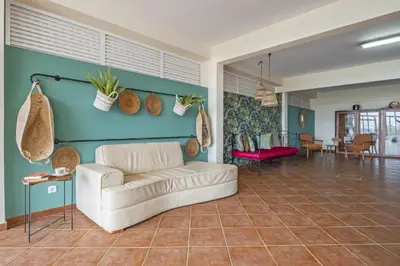 a living room with a white couch and a blue wall at Casas do Salao by Homie in Porto Moniz