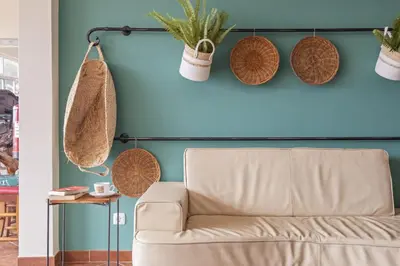 a couch in front of a blue wall with potted plants at Casas do Salao by Homie in Porto Moniz