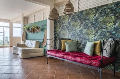 a living room with a red couch in front of a wall at Casas do Salao by Homie in Porto Moniz
