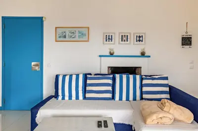 a large kitchen with white appliances and wooden cabinets at Casa da Praia in Vila Baleira