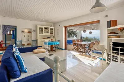 a living room with a blue couch and a table at Casa da Praia in Vila Baleira