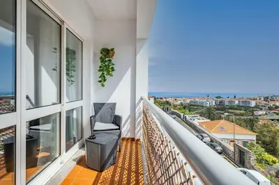 a balcony with a chair and a view of the city at My Place in Funchal by Homie in Funchal