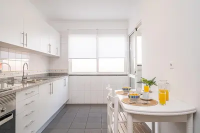 a white kitchen with a table with drinks on it at My Place in Funchal by Homie in Funchal