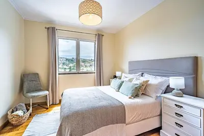 a bedroom with a bed with a chair and a window at My Place in Funchal by Homie in Funchal