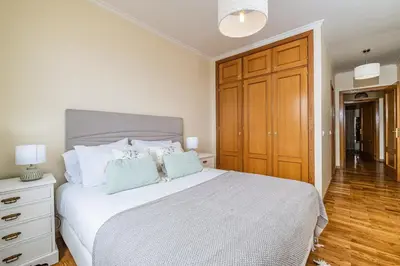 a bedroom with a large bed with a wooden cabinet at My Place in Funchal by Homie in Funchal