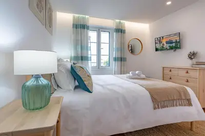 a bedroom with a bed and a table with a lamp at Casa de Sao Tiago 2 in Funchal