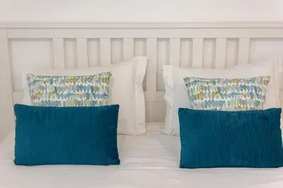 two blue pillows and two white pillows on a bed at Casa de Sao Tiago 2 in Funchal
