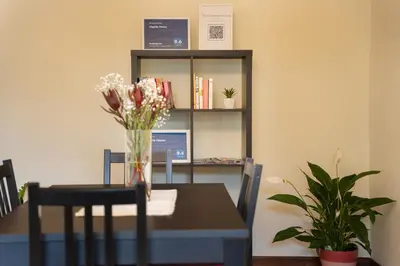 a dining room table with a vase of flowers on it at Vigário House in Câmara de Lobos