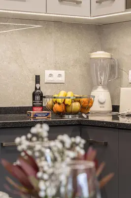 a kitchen counter with a bowl of fruit and a blender at Vigário House in Câmara de Lobos
