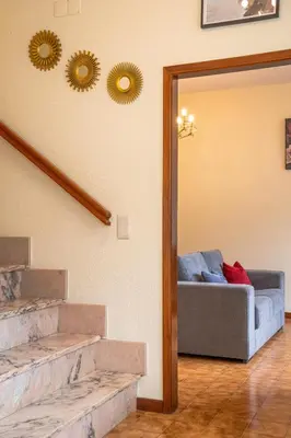 a living room with a couch and mirrors on the wall at Vigário House in Câmara de Lobos