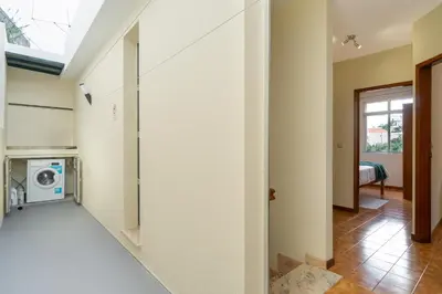 a hallway with a washer and dryer in a house at Vigário House in Câmara de Lobos