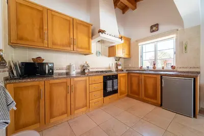 a kitchen with wooden cabinets and stainless steel appliances at Bliss Villa in Aljezur