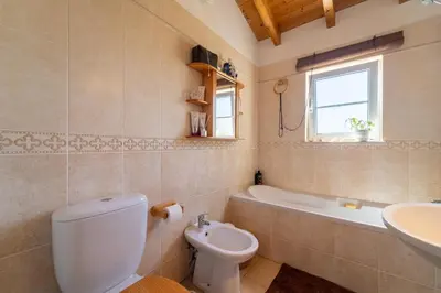 a bathroom with a toilet and a sink and a tub at Bliss Villa in Aljezur