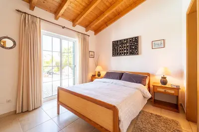 a bedroom with a bed and a large window at Bliss Villa in Aljezur