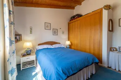 a bedroom with a large bed with a wooden headboard at Bliss Villa in Aljezur