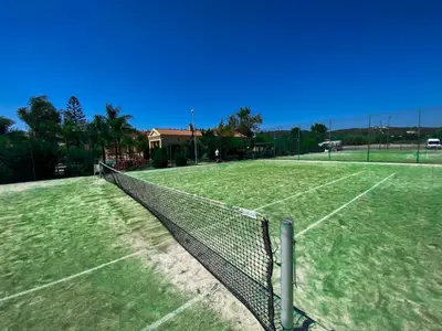 a tennis court with a net on top of it at Baia da Luz - Nuzone Apartment in Luz