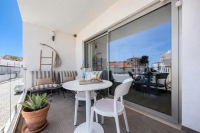 a balcony with a white table and chairs at Filha do Pisco in Burgau
