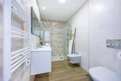 a white bathroom with a sink and a toilet at Filha do Pisco in Burgau